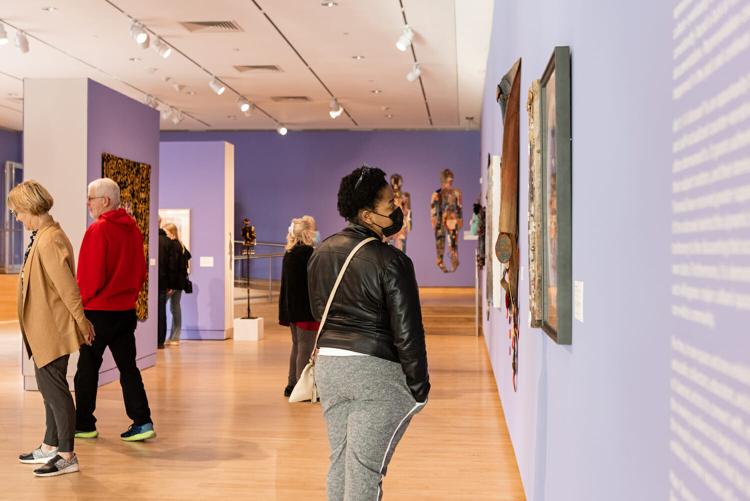 person looking at paintings in a museum gallery
