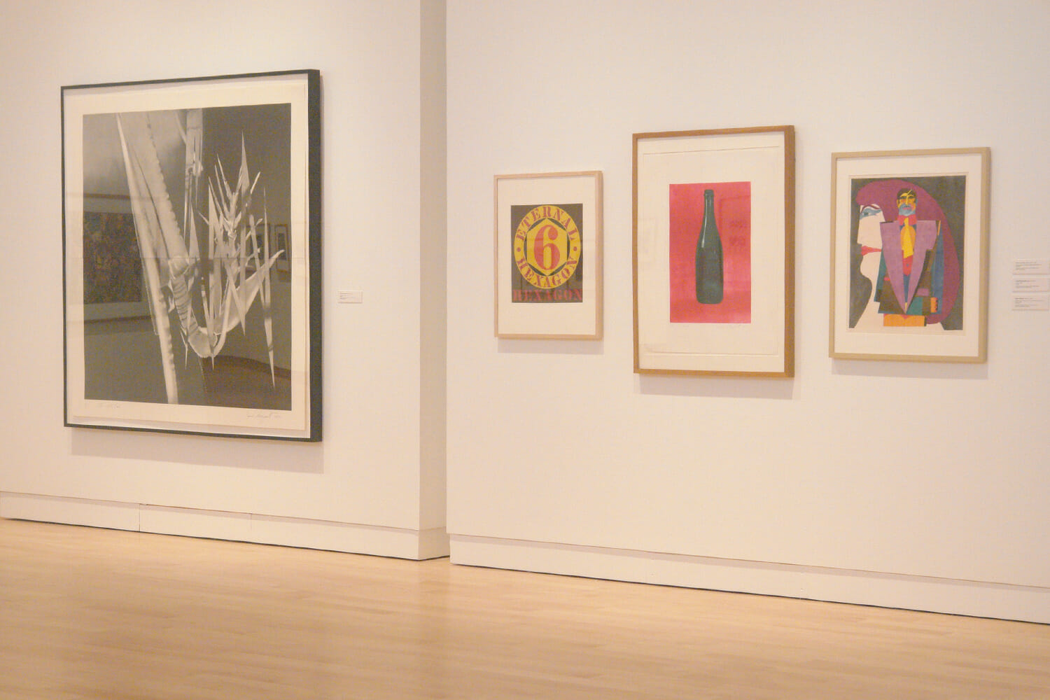 installation view of "In Depth," featuring four framed artworks hanging across two mobile walls