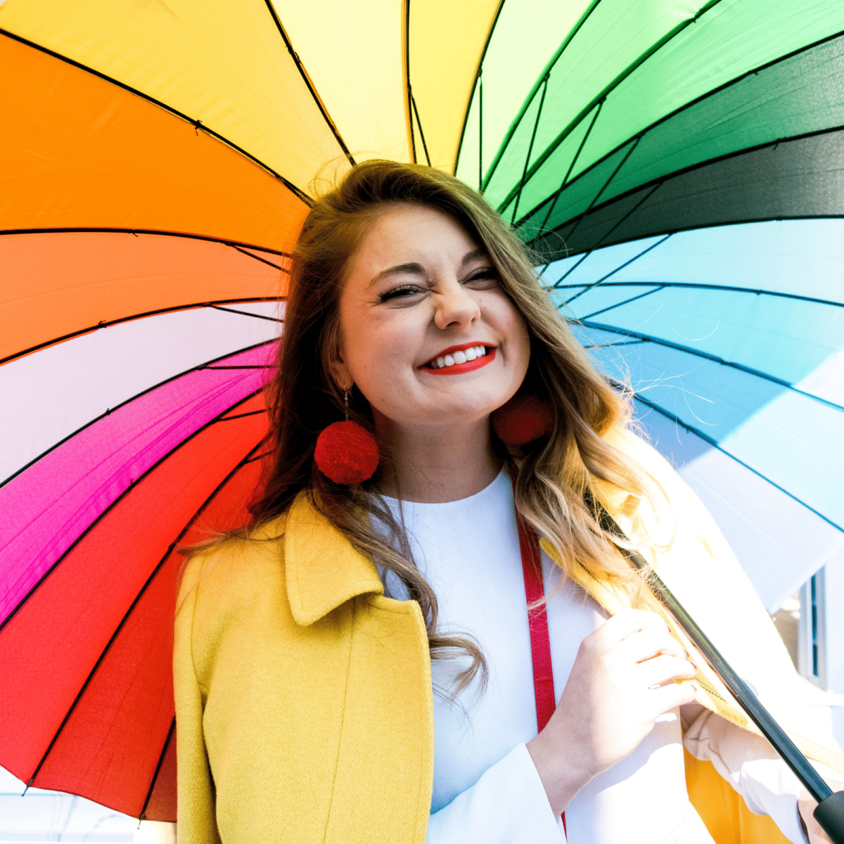 Allie holding a rainbow umbrella
