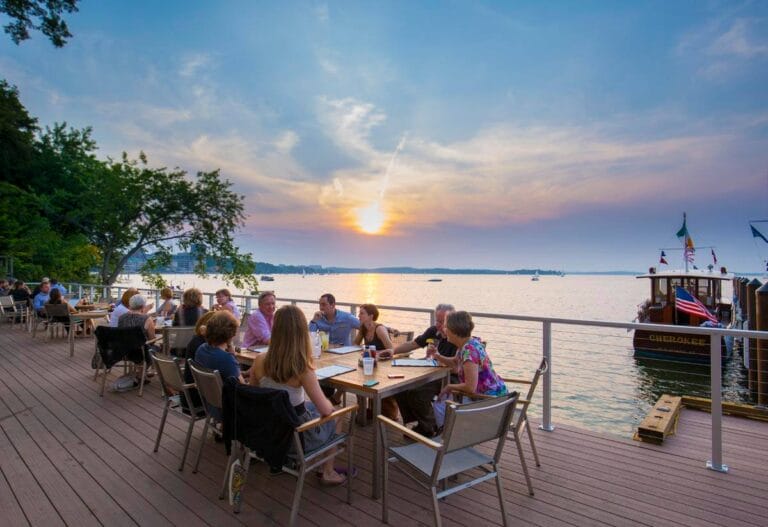 People Eating at Boathouse During Sunset